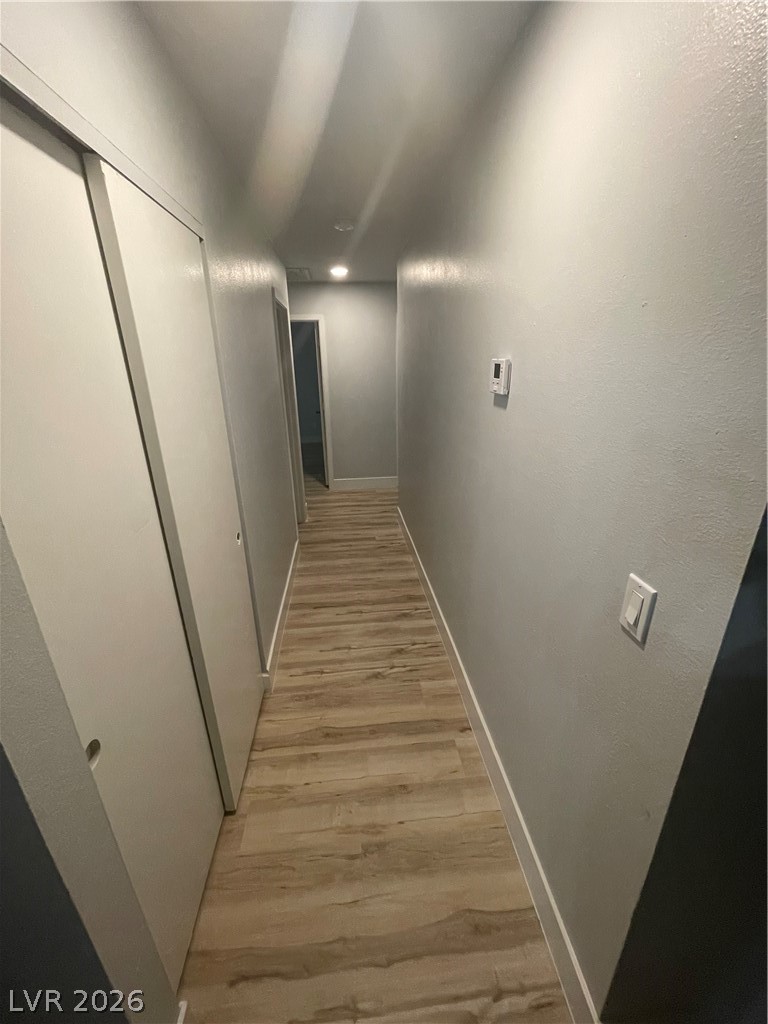 466 East Sunset Road, Unit D Henderson, NV 89011 - Photo 8 of 20 Hallway featuring light wood-style floors and a textured wall