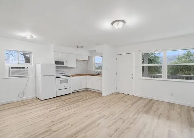 a white kitchen with sink and cabinets
