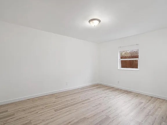 1302 South Quinlan Park Road Austin, TX 78732 - Photo 19 of 40 Unfurnished room featuring light wood-style flooring and baseboards
