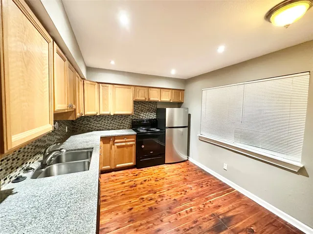 a kitchen with a refrigerator and a stove top oven