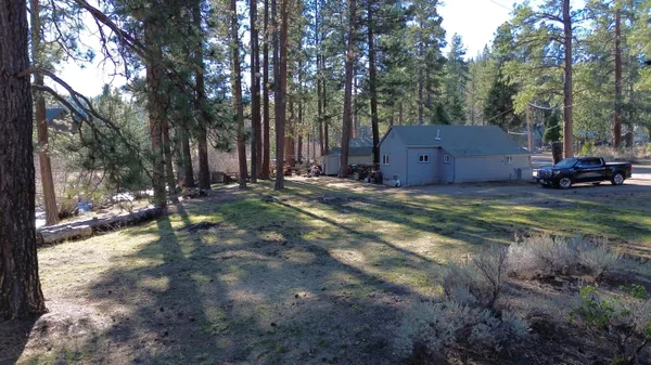a view of a house with a yard and tree