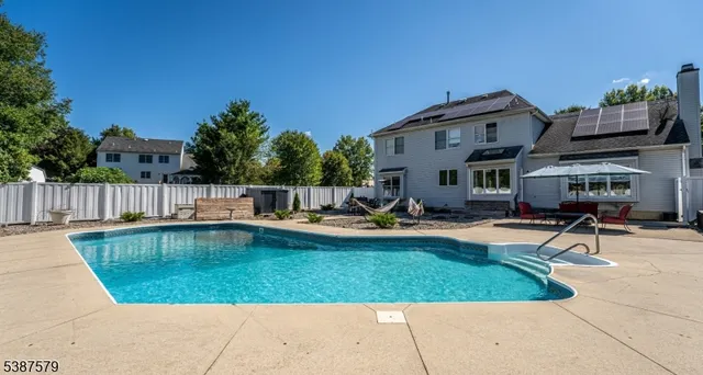 a view of a house with swimming pool and sitting area