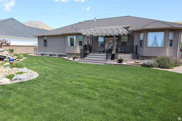 1055 North 1000 East Mapleton, UT 84664 - Photo 84 of 112 Expansive green lawn with a tiered wood deck featuring black railings and a white pergola