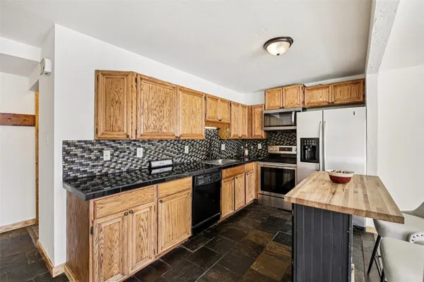 a kitchen with stainless steel appliances a sink stove and refrigerator