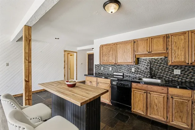 a kitchen with stainless steel appliances granite countertop a refrigerator stove top oven and sink