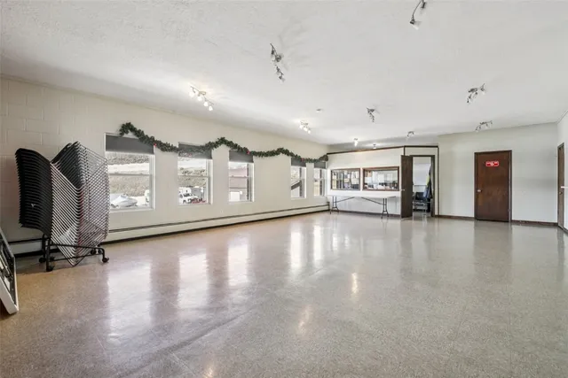 a view of an empty room with window and cabinet