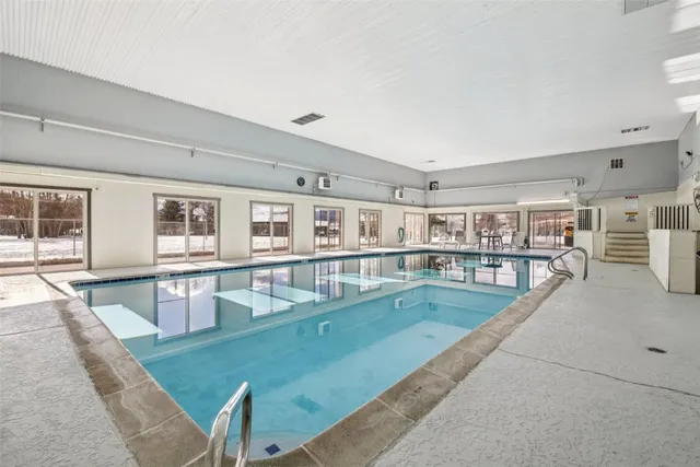 a view of a kitchen with kitchen island stainless steel appliances sink refrigerator and stove