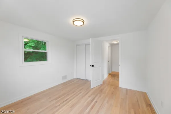 a view of a room with wooden floor and a window