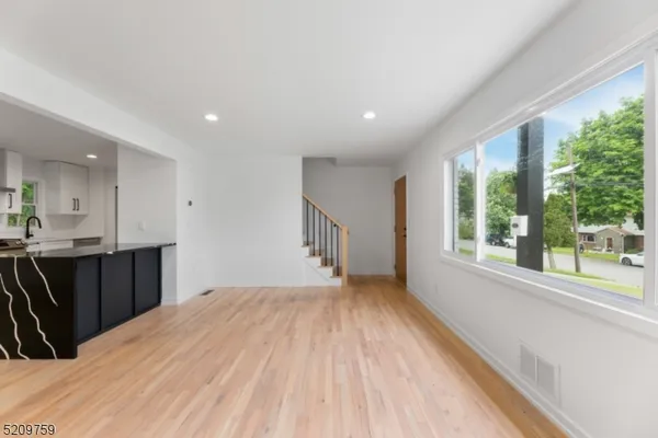 a view of a kitchen with wooden floor and a window