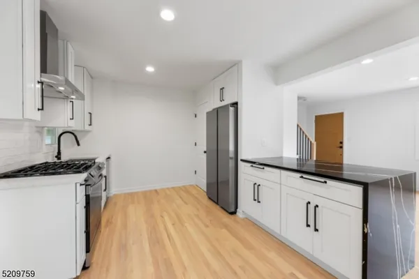 a kitchen with granite countertop a sink stove and refrigerator