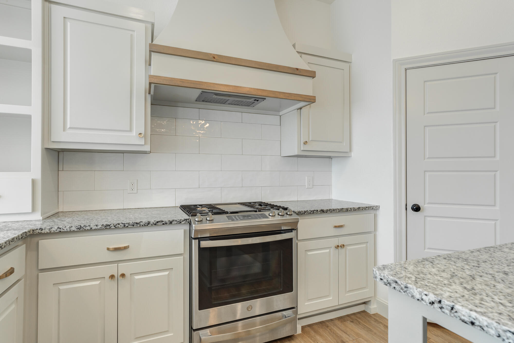 6805 51st Street Lubbock, TX 79407 - Photo 11 of 41 a kitchen with granite countertop white cabinets and a stove