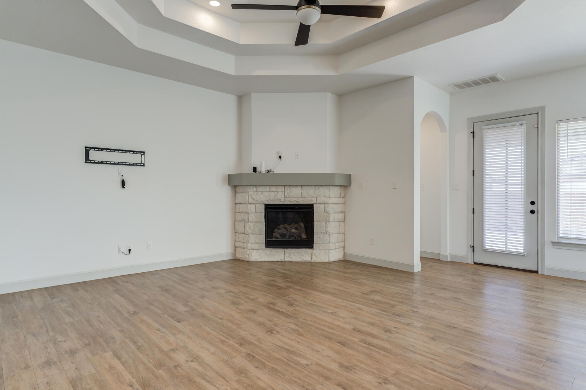 6805 51st Street Lubbock, TX 79407 - Photo 14 of 41 a view of an empty room with wooden floor fireplace and a window