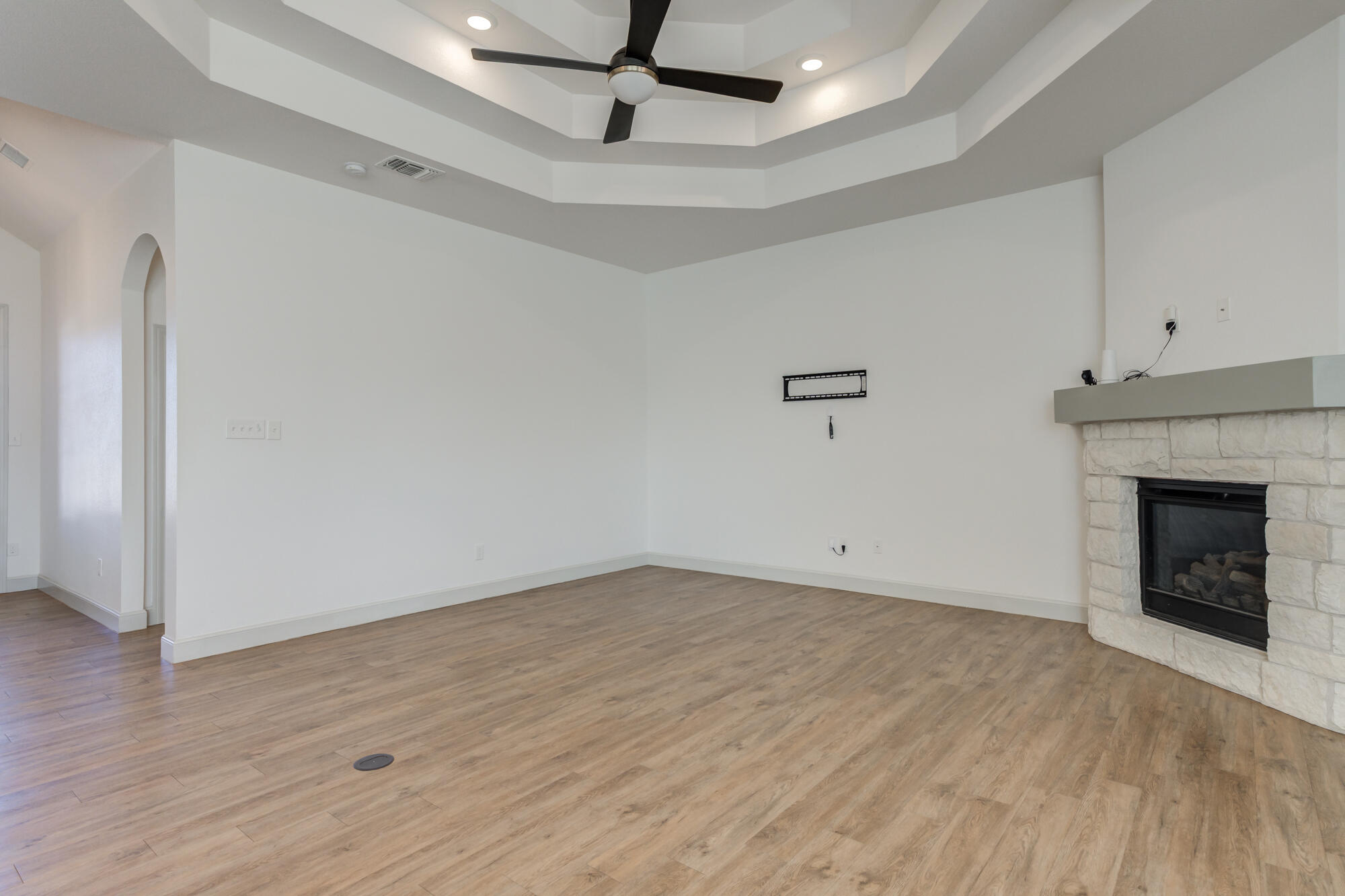6805 51st Street Lubbock, TX 79407 - Photo 16 of 41 a view of an empty room with wooden floor and a fireplace