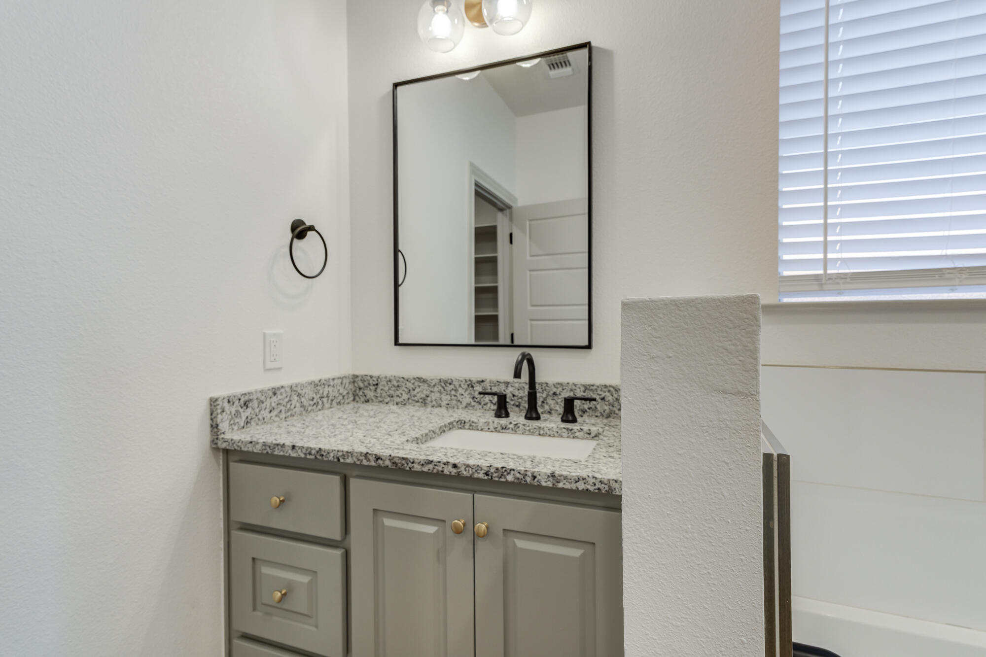 6805 51st Street Lubbock, TX 79407 - Photo 25 of 41 a bathroom with a granite countertop sink vanity and a mirror
