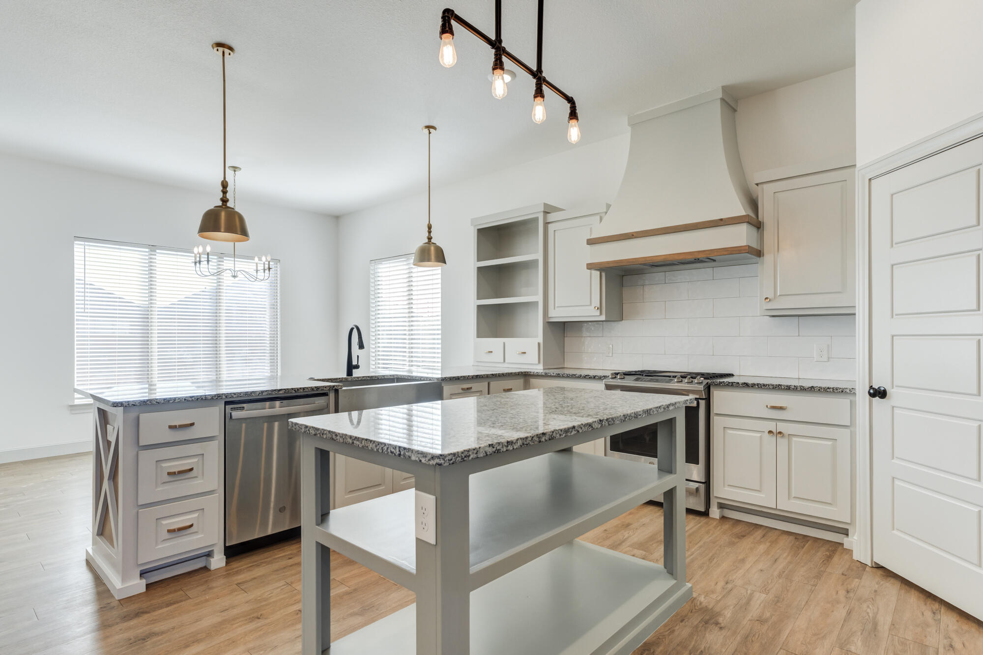 6805 51st Street Lubbock, TX 79407 - Photo 6 of 41 a kitchen with kitchen island a stove a sink and wooden floor