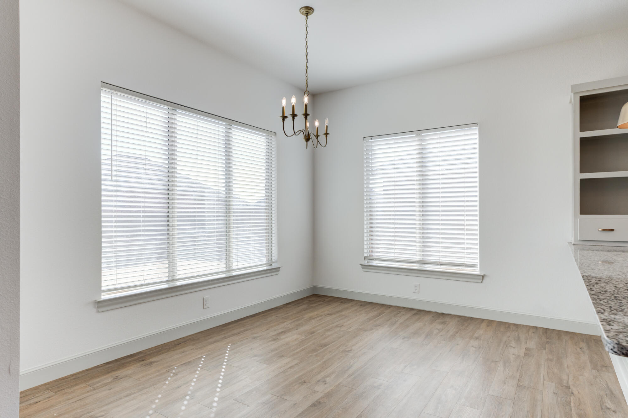 6805 51st Street Lubbock, TX 79407 - Photo 8 of 41 a view of an empty room with a window and wooden floor