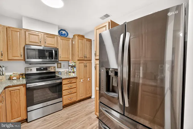 a kitchen with stainless steel appliances a refrigerator and a stove top oven