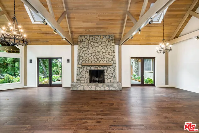a view of an empty room with a fireplace and a window