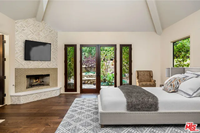 a bedroom with a large bed and a fireplace