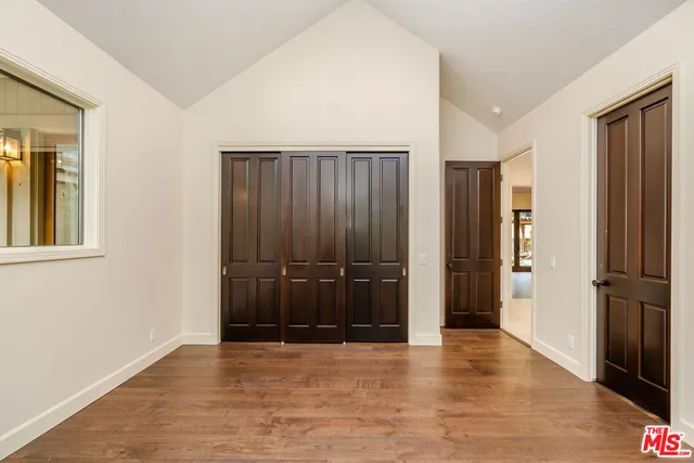 an empty room with closet and wooden floor
