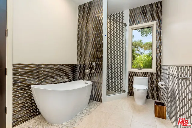 a white tub sitting next to a small white wall