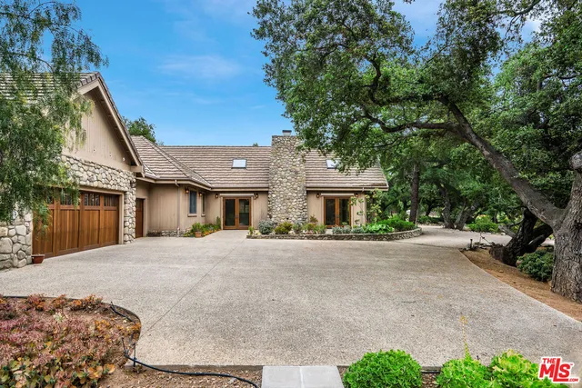 a front view of a house with yard and parking
