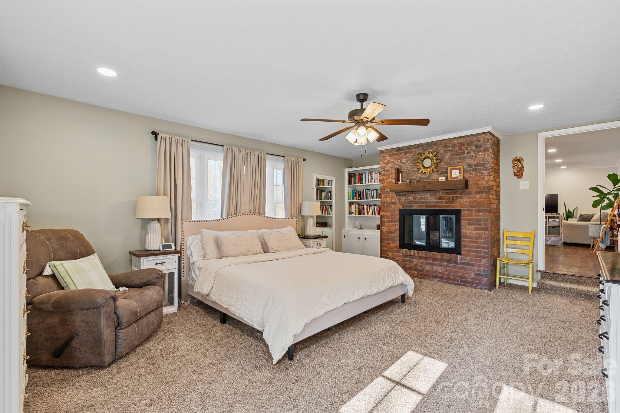 1348 Jenkins Valley Road Alexander, NC 28701 - Photo 11 of 44 a spacious bedroom with a bed and a fireplace