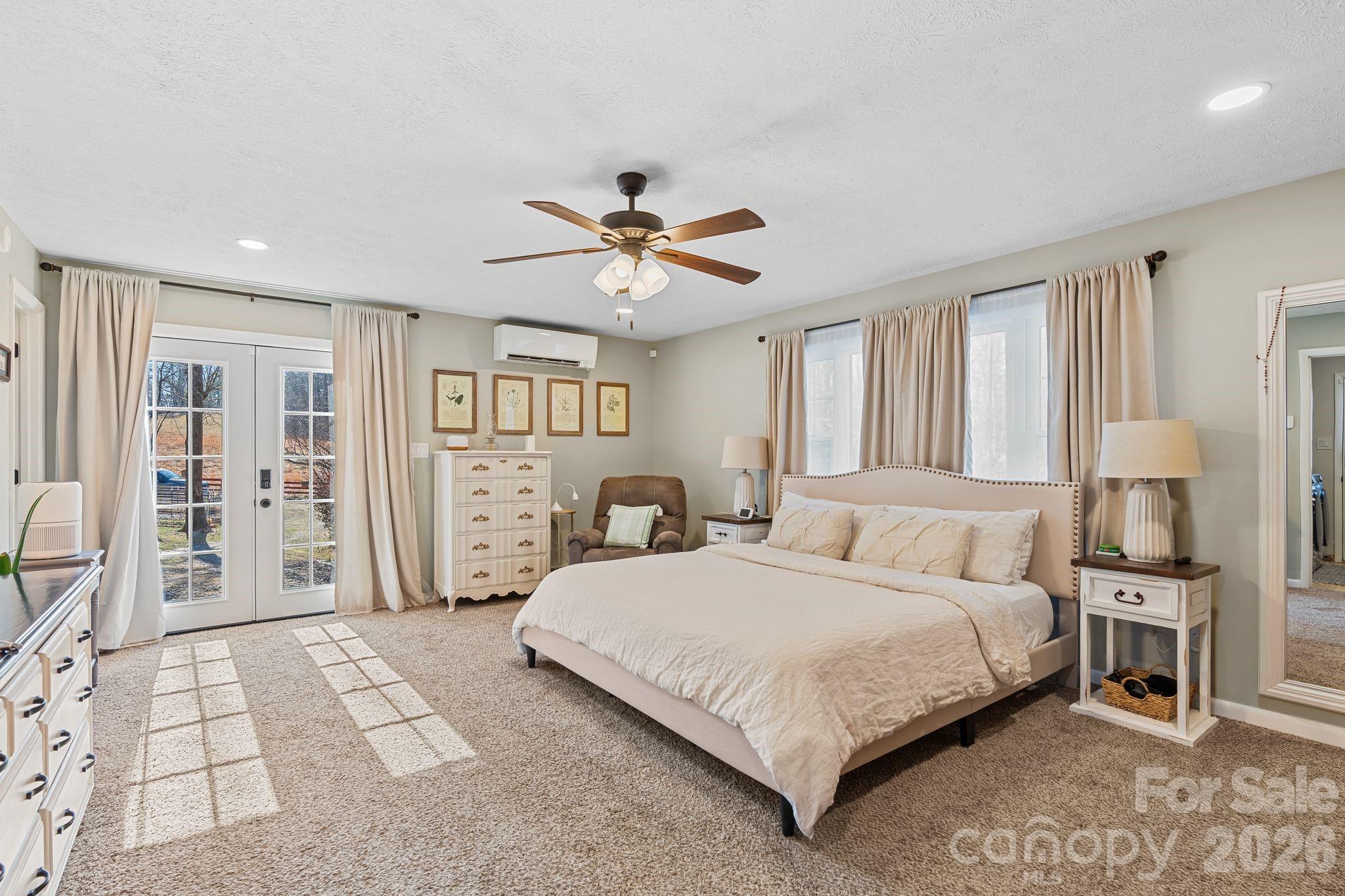 1348 Jenkins Valley Road Alexander, NC 28701 - Photo 13 of 44 a bedroom with a large bed a chandelier and windows