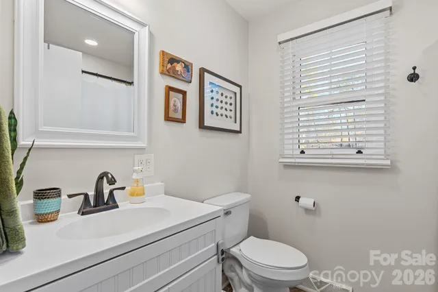 a bathroom with a sink a toilet and a window