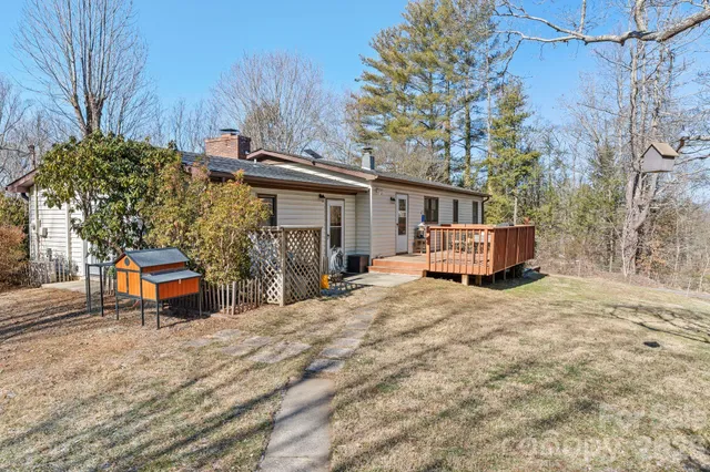 a yellow house sitting in the middle of a yard