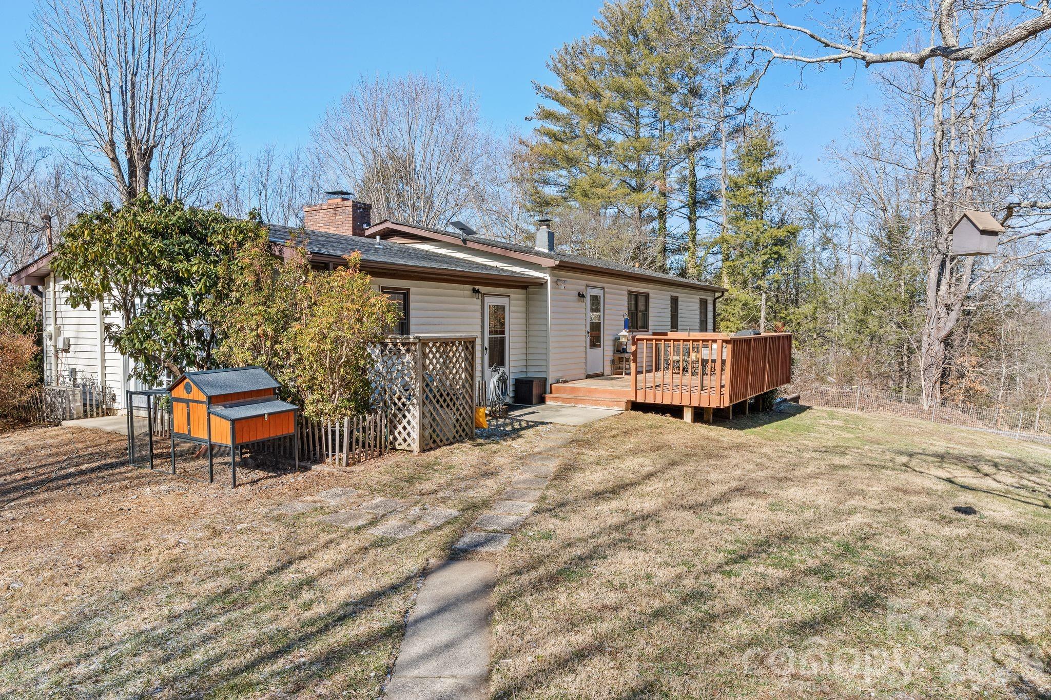 1348 Jenkins Valley Road Alexander, NC 28701 - Photo 22 of 44 a yellow house sitting in the middle of a yard