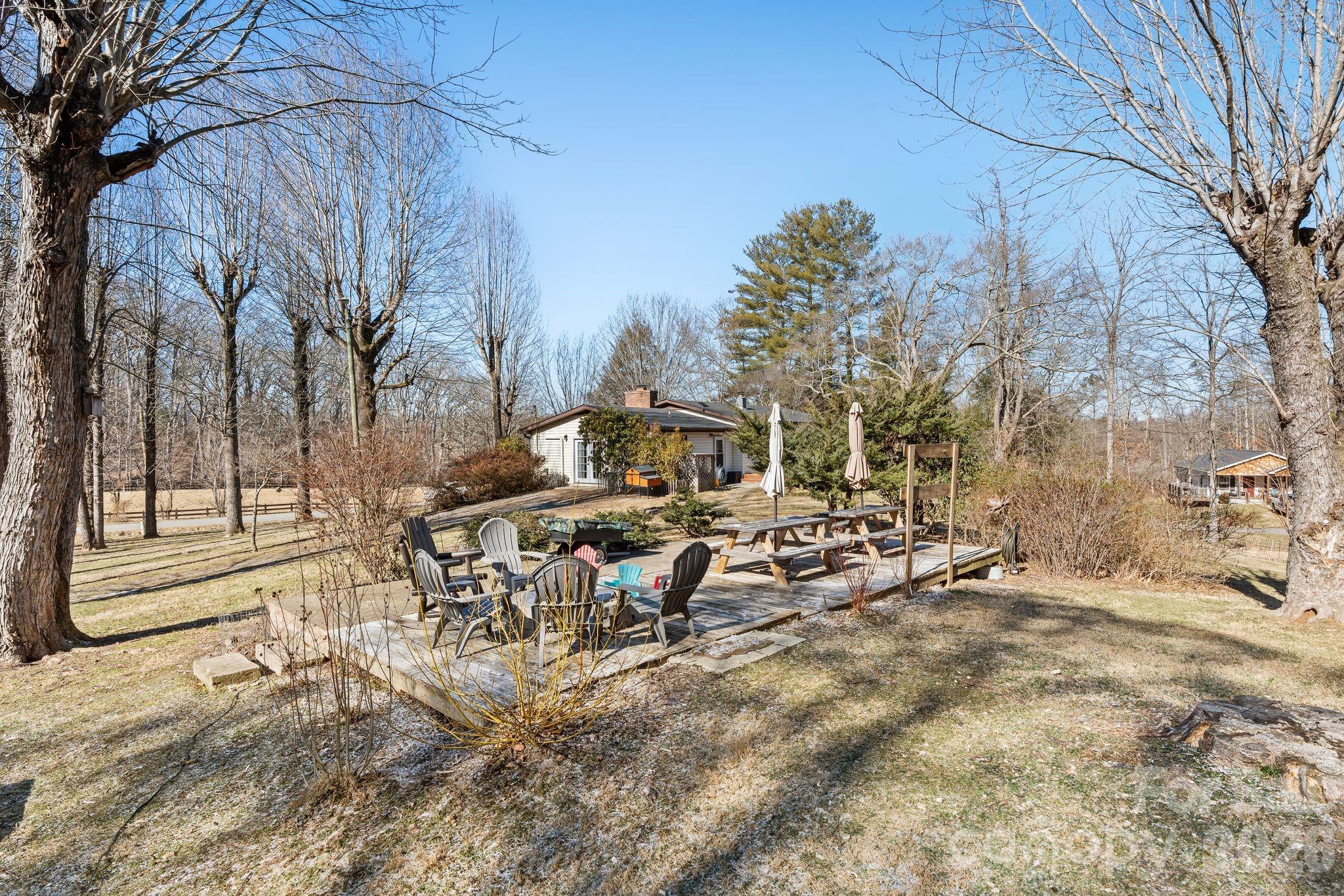 1348 Jenkins Valley Road Alexander, NC 28701 - Photo 28 of 44 a view of a yard with a bench in a patio