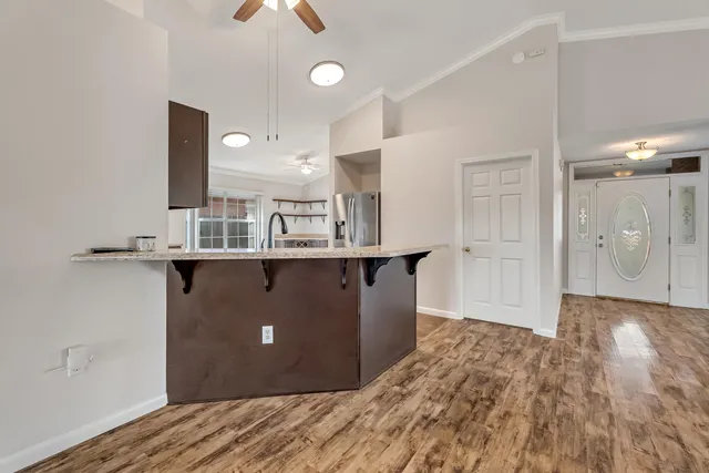 a view of kitchen with stainless steel appliances granite countertop a refrigerator and a sink