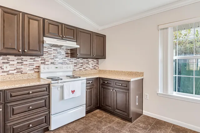 a kitchen with a stove sink and cabinets
