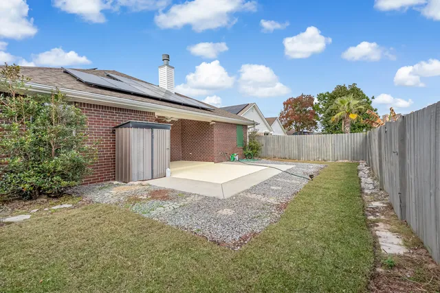 a view of a white house with a yard and table and chairs