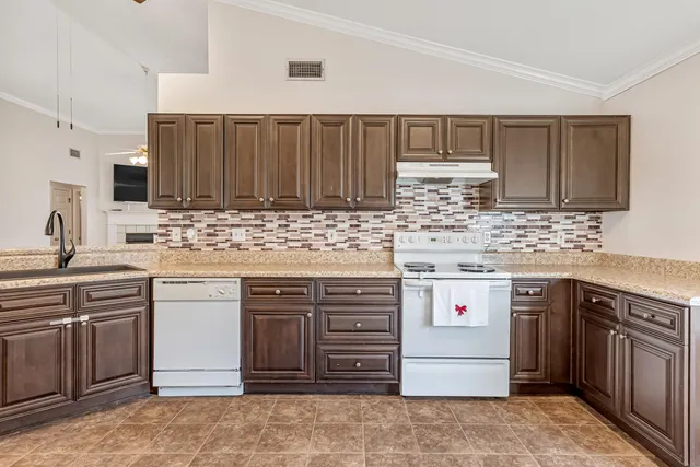 a kitchen with stainless steel appliances granite countertop a stove sink and cabinets
