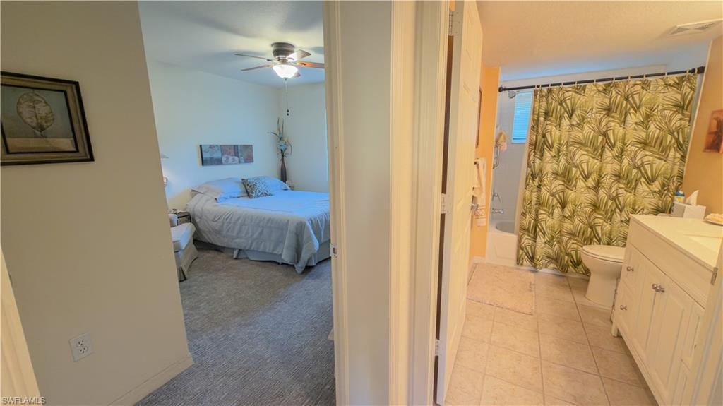 8298 Key Royal Lane, Unit 413 Naples, FL 34119 - Photo 12 of 18 Bedroom with ceiling fan and light carpet