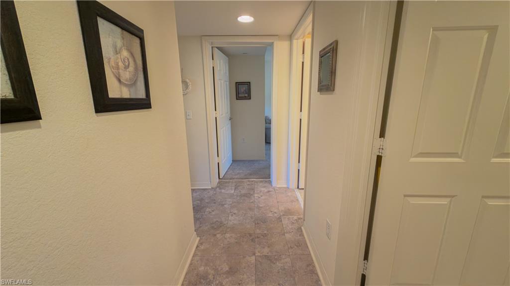 8298 Key Royal Lane, Unit 413 Naples, FL 34119 - Photo 13 of 18 Hall with baseboards and recessed lighting