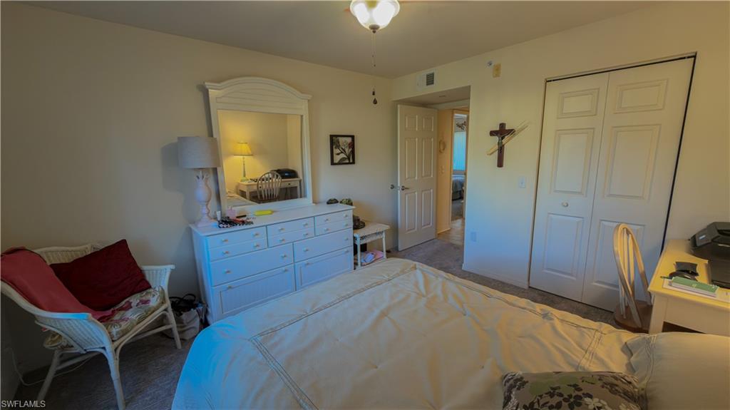 8298 Key Royal Lane, Unit 413 Naples, FL 34119 - Photo 15 of 18 Bedroom with a closet and carpet flooring