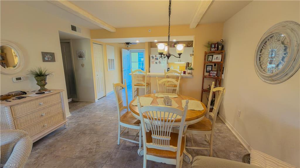 8298 Key Royal Lane, Unit 413 Naples, FL 34119 - Photo 4 of 18 Dining area with suspended lighting and beam ceiling