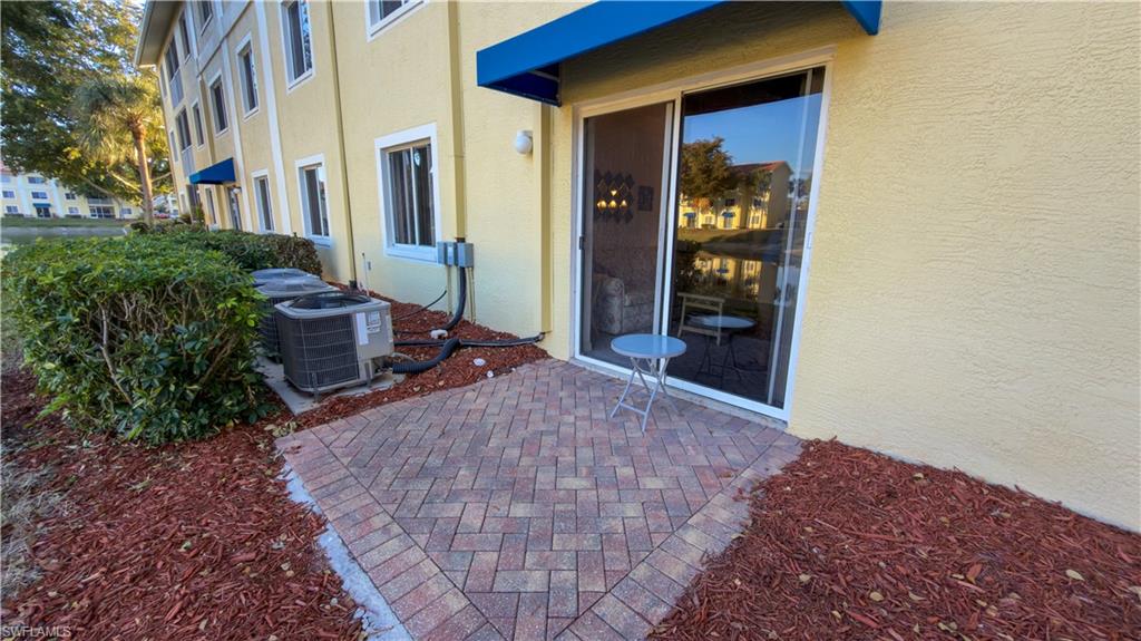 8298 Key Royal Lane, Unit 413 Naples, FL 34119 - Photo 7 of 18 Property entrance with stucco siding and a patio area