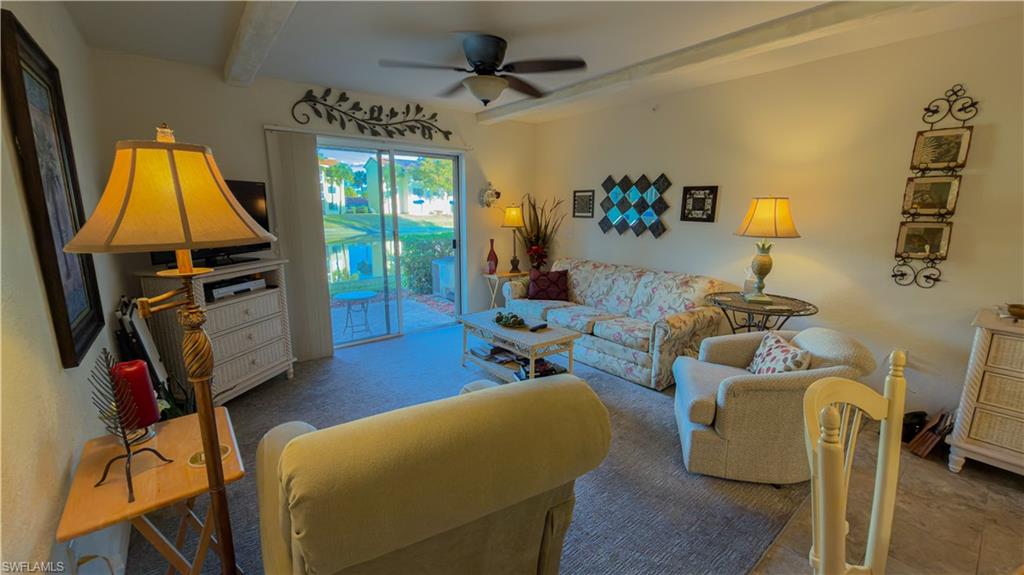 8298 Key Royal Lane, Unit 413 Naples, FL 34119 - Photo 8 of 18 Living area featuring ceiling fan, beam ceiling, and carpet floors