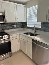 a kitchen with granite countertop white cabinets and white appliances