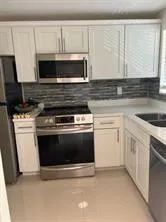 a kitchen with granite countertop a stove and a microwave