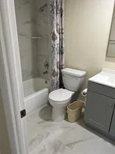 a white toilet sitting next to a bath tub