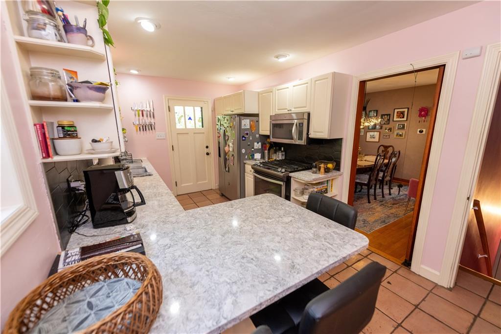 108 Cascade Road Pittsburgh, PA 15221 - Photo 16 of 42 a kitchen with stainless steel appliances granite countertop a sink stove and refrigerator