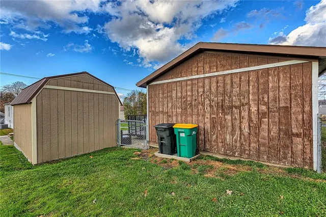 a view of backyard of house and wooden fence