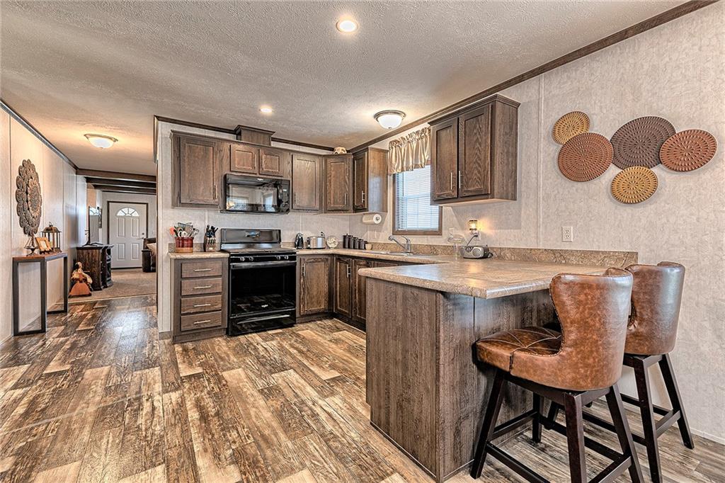 104 Clifton Street Derry, PA 15627 - Photo 7 of 35 a kitchen with stainless steel appliances granite countertop a stove top oven a sink a dining table and chairs with wooden floor