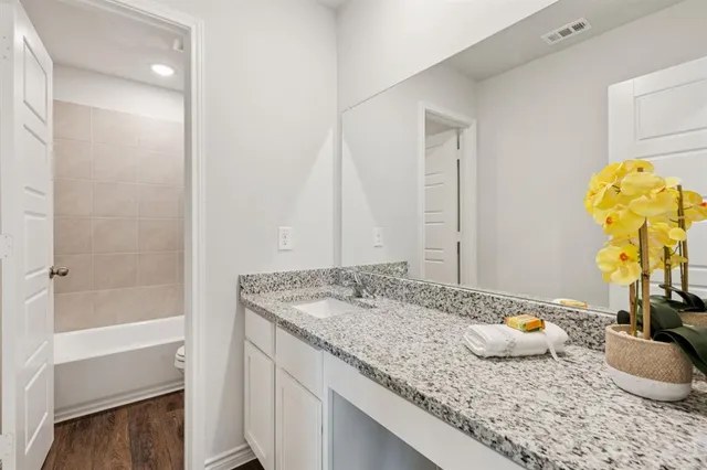 a bathroom with a granite countertop sink and a mirror