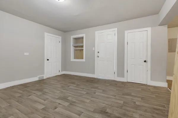 a view of an empty room with wooden floor